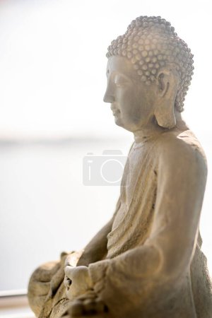 Téléchargez les photos : Gros plan de la sculpture de bouddha contre la mer et ciel clair pendant la journée ensoleillée - en image libre de droit