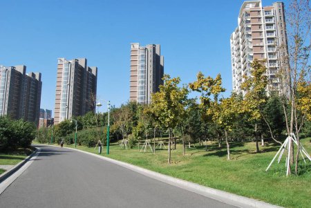 Photo for A paved road with tall apartment buildings in a residential setting - Royalty Free Image