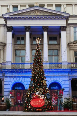 Téléchargez les photos : Une verticale d'arbre de Noël avec des lumières, des boules colorées et des étoiles à l'extérieur - en image libre de droit