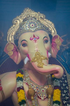 Téléchargez les photos : L'idole du Seigneur Ganesha étant vénérée lors d'un mandat à Mumbai pour Ganesh Chaturthi, dans un plan vertical - en image libre de droit