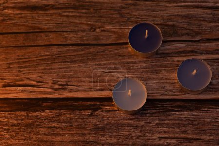 Téléchargez les photos : Un gros plan de petites bougies sur une table en bois - en image libre de droit