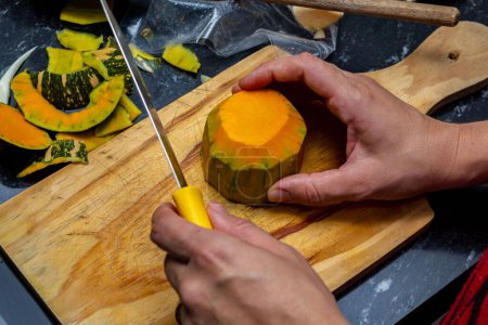 Photo for A top view of a person in the process of cutting and preparing zucchini on a wooden board - Royalty Free Image