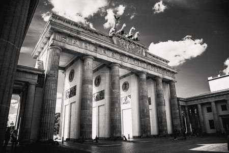Téléchargez les photos : Vue en niveaux de gris du monument de la Porte de Brandebourg à Berlin avec un ciel nuageux - en image libre de droit