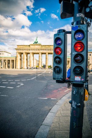 Téléchargez les photos : Vue verticale des feux de circulation et de la Porte de Brandebourg Monument derrière un ciel nuageux bleu à Berlin - en image libre de droit