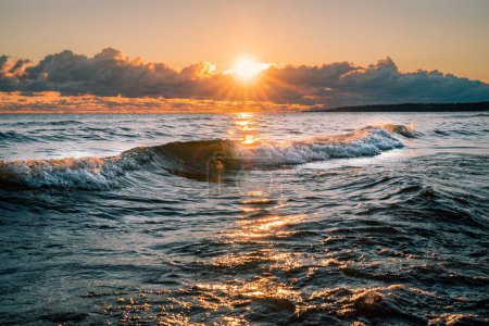 Téléchargez les photos : La belle vue sur les vagues de la mer sur le fond du ciel au coucher du soleil. - en image libre de droit