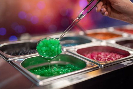 Téléchargez les photos : Un gros plan d'une pelle à main vert nourriture de caviar de poteaux exposés à vendre dans le restaurant - en image libre de droit
