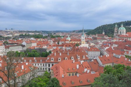 Photo for An aerial shot of the red-roofed city of Prague under the gloomy sky on a summer day - Royalty Free Image