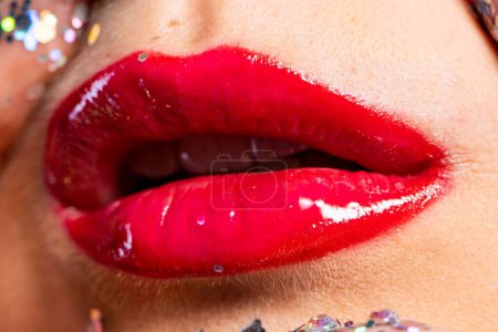 Photo for Close-up of beautiful young woman with bright red glossy lipstick touching face with shiny glitters - Royalty Free Image