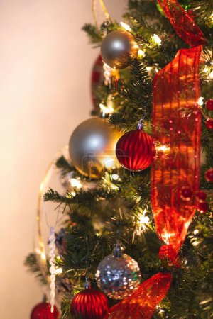 Téléchargez les photos : Gros plan vertical d'un sapin de Noël décoré avec un mur beige en arrière-plan - en image libre de droit