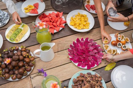 Téléchargez les photos : Un plan grand angle d'une table en bois aux fruits tropicaux et exotiques tranchés - en image libre de droit