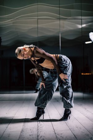 Téléchargez les photos : Un plan vertical d'une belle danseuse posant en mesh superposition crop top en pantalon noir et baggy - en image libre de droit