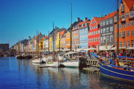 Foto de Una hermosa toma de barcos atracados en el canal Nyhavn cerca de los coloridos edificios en Copenhague, Dinamarca - Imagen libre de derechos