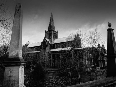 Photo for A greyscale shot of an old church with gravestones in the foreground in Scotland - Royalty Free Image
