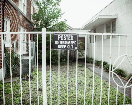 Foto de Un primer plano de Keep Out Sign en una valla de metal blanco - Imagen libre de derechos