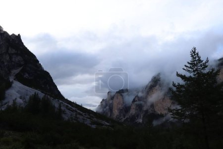 Téléchargez les photos : Un paysage de montagnes rocheuses des Dolomites et un ciel de fumée brumeuse dans le Trentin-Tyrol du Sud, Italie - en image libre de droit