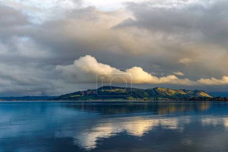 Téléchargez les photos : Une vue pittoresque du lac Rotorua avec un reflet de belles collines et de nuages duveteux, Nouvelle-Zélande - en image libre de droit
