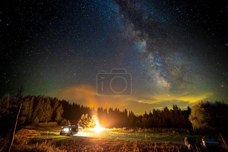 Foto de Una hoguera y los árboles bajo un cielo estrellado. - Imagen libre de derechos