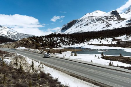 Téléchargez les photos : Un VR sur une route dégagée entourée de montagnes enneigées en Alberta, Canada - en image libre de droit