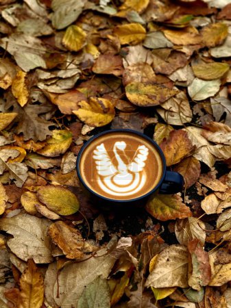 Téléchargez les photos : Un gros plan de latte art sur les feuilles d'automne - en image libre de droit