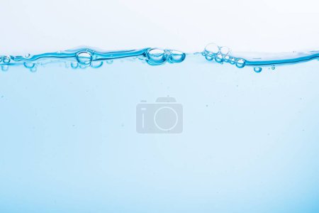 Foto de Un primer plano de agua azul y algunas burbujas en la superficie sobre un fondo blanco - Imagen libre de derechos
