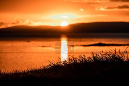 Téléchargez les photos : Un beau cliché d'un ciel orangé brillant au-dessus de l'eau à l'île de Skye, en Écosse - en image libre de droit