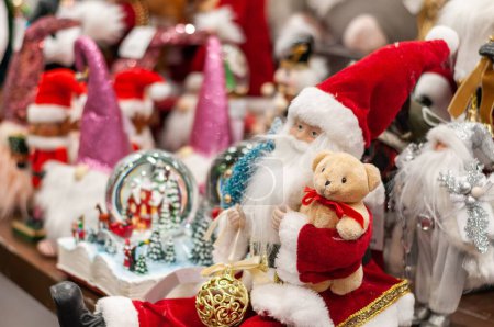 Téléchargez les photos : Un gros plan de Noël Santa Clause tenant un jouet d'ours en peluche, gants de neige - en image libre de droit