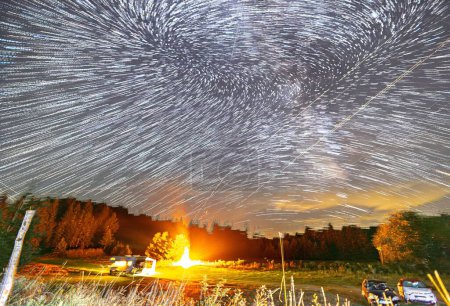 Foto de Una hoguera y los árboles bajo un cielo estrellado. - Imagen libre de derechos