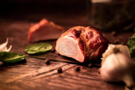 Téléchargez les photos : Un gros plan de viande fraîche savoureuse sur une table en bois avec ajout d'herbes fraîches et d'épices aromatiques - en image libre de droit