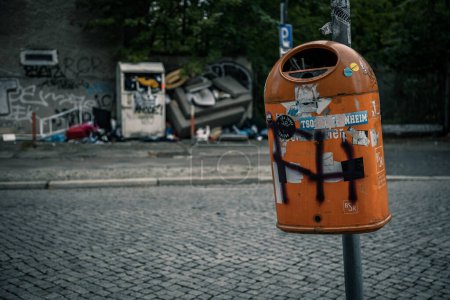 Téléchargez les photos : Une poubelle de rue suspendue à un poteau sur fond flou - en image libre de droit
