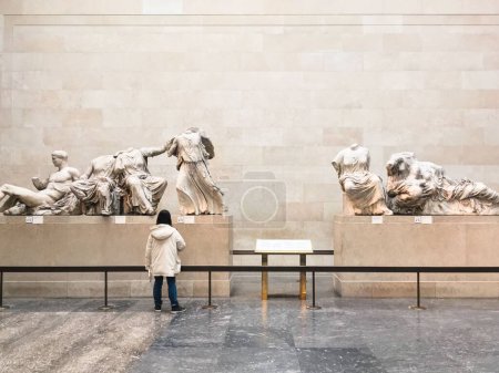 Photo for A view woman observing the friezes of the Parthenon in the British Museum - Royalty Free Image