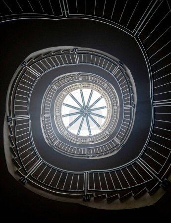 Foto de Una toma vertical de ángulo bajo de una escalera de caracol contra una claraboya. - Imagen libre de derechos