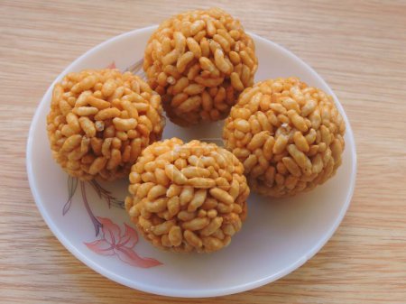 Foto de Dulce bola redonda en forma de crujiente y ligera llamada Murmura laddu en la India preparada con arroz inflado y jarabe de jaggery. - Imagen libre de derechos