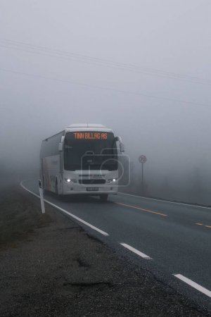 Téléchargez les photos : Plan vertical d'un bus traversant le brouillard dans les montagnes norvégiennes dans de mauvaises conditions - en image libre de droit