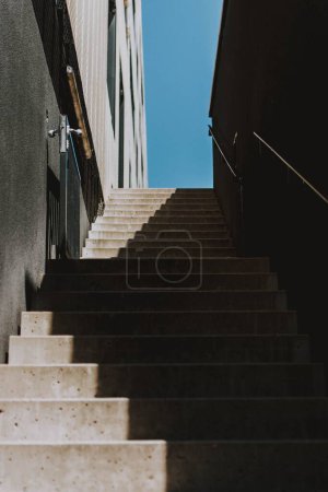 Un plano vertical de escaleras de piedra de un edificio bajo la sombra del sol