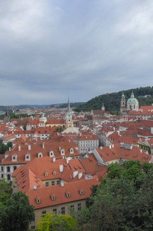 Photo for A vertical shot of the red-roofed city of Prague surrounded by green trees - Royalty Free Image