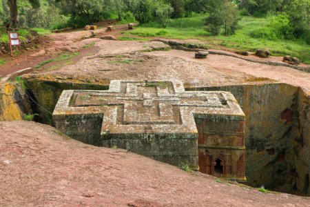 Photo for The cross-shaped Rock-hewn Church of Saint George surrounded by green grass and trees in Lalibela, Ethiopia - Royalty Free Image
