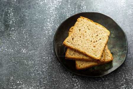 Photo for A top view of slices of loaf bread with natural fermentation on a dark plate - Royalty Free Image
