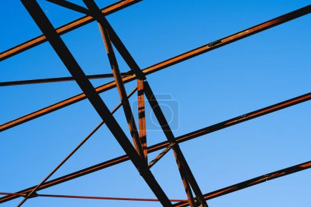 Photo for A low-angle shot of the steel truss and purlin of a building under a beautiful blue sky - Royalty Free Image