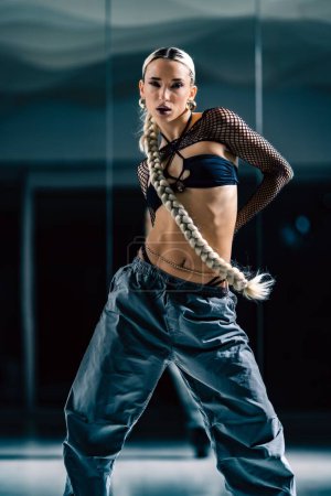 Téléchargez les photos : Un plan vertical d'une belle danseuse posant en mesh superposition crop top en pantalon noir et baggy - en image libre de droit