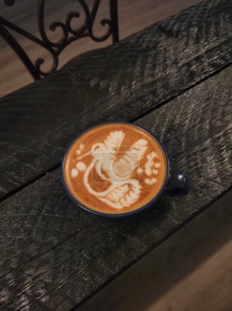 Photo for A closeup of latte art on a wooden table - Royalty Free Image