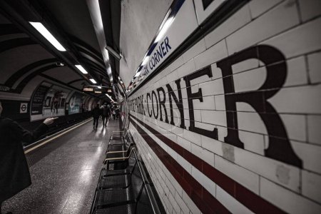 Téléchargez les photos : Un plan en niveaux de gris de la station de métro de Londres, Hyde Park Corner signe et les gens - en image libre de droit