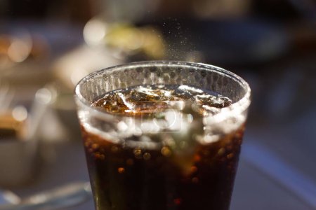 Photo for A closeup of a glass of iced refreshing soda on a blurry background - Royalty Free Image