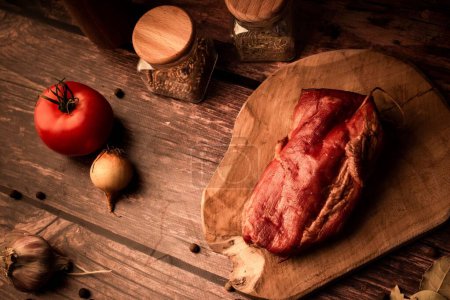 Foto de Una vista superior de la carne fresca y sabrosa en una mesa de madera con la adición de hierbas frescas y especias aromáticas - Imagen libre de derechos