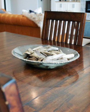 Foto de Una toma vertical de objetos decorativos en un plato sobre la mesa de madera en una sala de estar moderna - Imagen libre de derechos