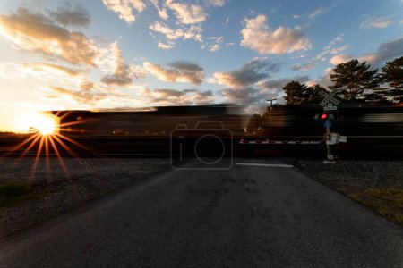 Téléchargez les photos : Un beau plan d'un train en mouvement flou pendant le coucher du soleil - en image libre de droit