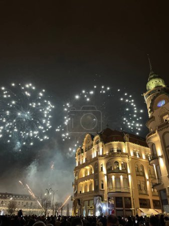 Photo for Colorful glowing fireworks blasting over Black Eagle Palace in the city center of Oradea at night - Royalty Free Image