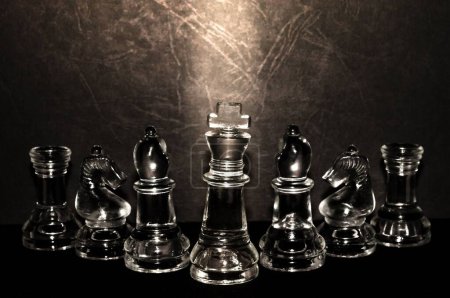 Téléchargez les photos : Un gros plan de figurines d'échecs transparentes avec le fond sombre - en image libre de droit