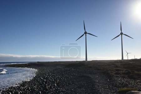 Foto de Las turbinas eólicas en una playa en un día soleado - el concepto de energía renovable - Imagen libre de derechos