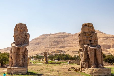 Téléchargez les photos : Vue de Colossi de Memnon, statues en pierre du pharaon Amenhotep III, dans la nécropole de Theban, située à l'ouest du Nil de Louxor, en Egypte - en image libre de droit
