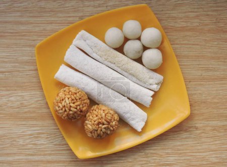 Téléchargez les photos : Nourriture assamaise connue sous le nom de pitha et laru préparée lors du festival Bihu à Assam, en Inde. Laru est une boule ronde préparée avec de la noix de coco et du riz soufflé. - en image libre de droit